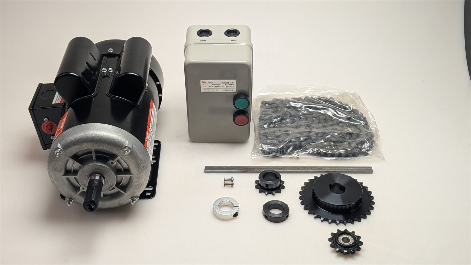 Shredder motor, control box, gears, fasteners, and hardware laid out on a white surface.
