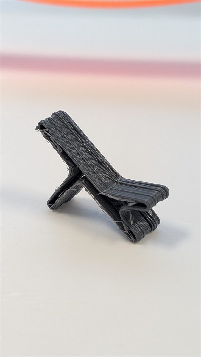 Small black 3D printed chair test part made from recycled material.